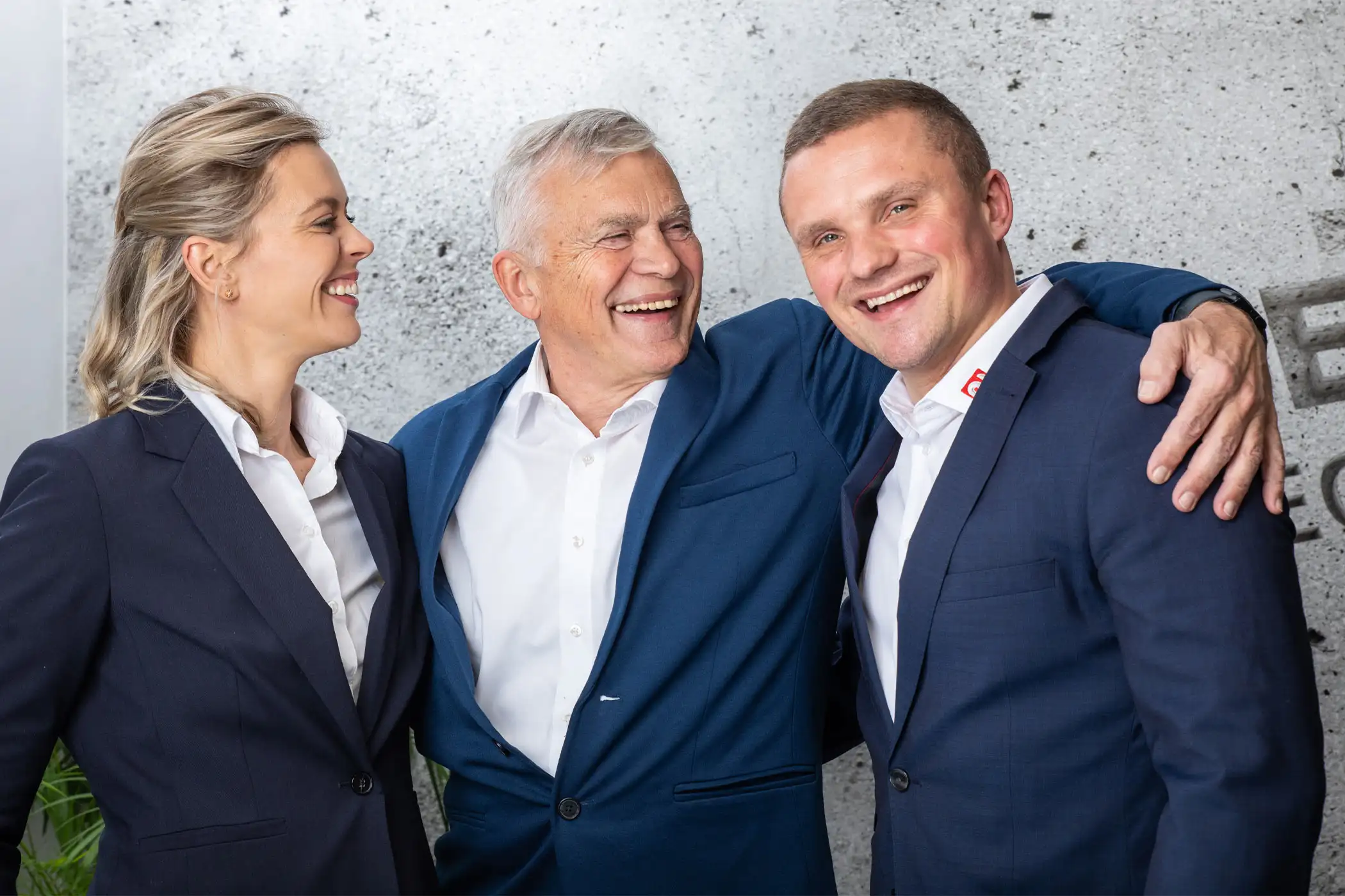 Familie Hermes von Hermes Technologie lachend vor einer Betonwand